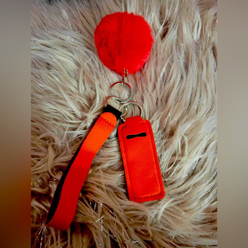 Solid orange chapstick holder wristlet with fuzzy ball